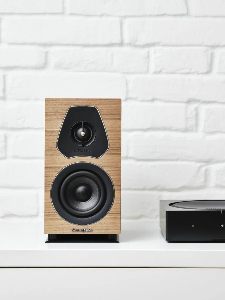 Een paar Sonus Faber Lumina I boekenplankspeakers in zwart leer en houtfineer afwerking, elegant weergegeven op een witte achte