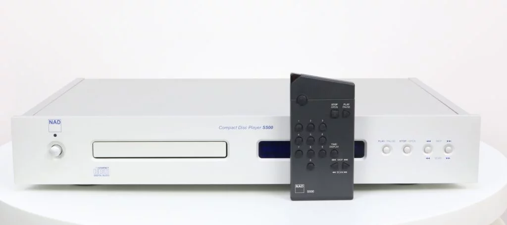 Vooraanzicht van de NAD S500 CD-speler met zilverkleurige afwerking en blauw display.