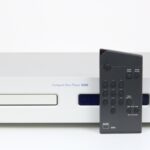 Vooraanzicht van de NAD S500 CD-speler met zilverkleurige afwerking en blauw display.