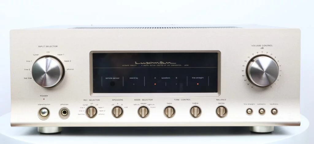 Afbeelding van de Luxman L-503s geïntegreerde versterker met een aluminium gouden voorpaneel en grijze behuizing, voorzien van diverse bedieningsknoppen en een duidelijk display.