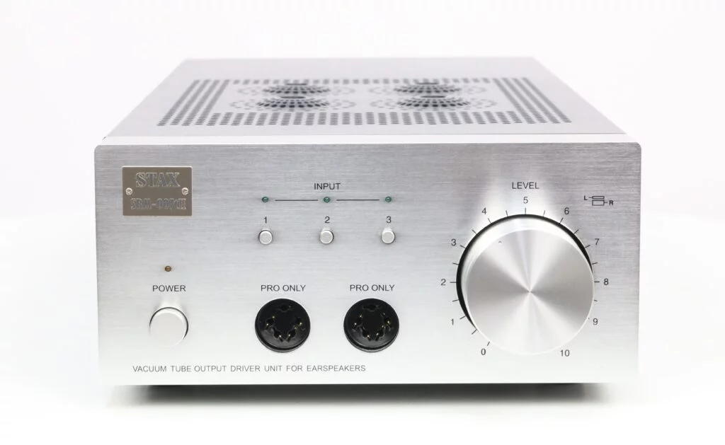 Afbeelding van de Stax SRM-007tII elektrostatistische hoofdtelefoonversterker met zilveren behuizing en strak ontwerp.