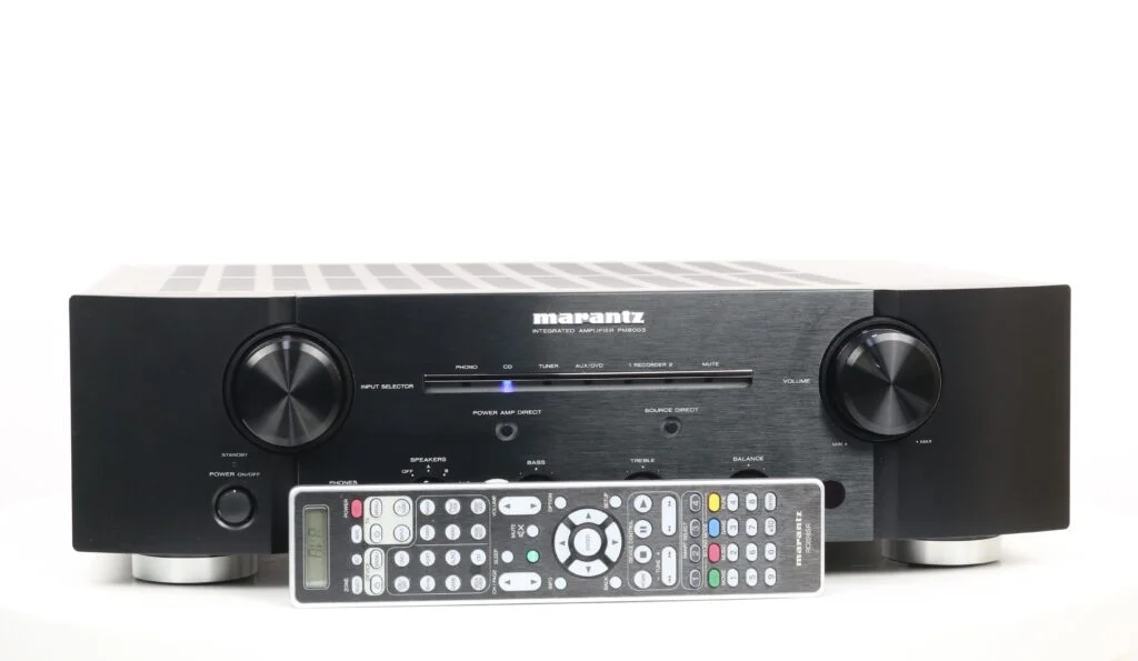 Vooraanzicht van de Marantz PM8003 geïntegreerde stereoversterker met vervangende afstandsbediening, in zwarte afwerking.
