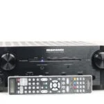 Vooraanzicht van de Marantz PM8003 geïntegreerde stereoversterker met vervangende afstandsbediening, in zwarte afwerking.